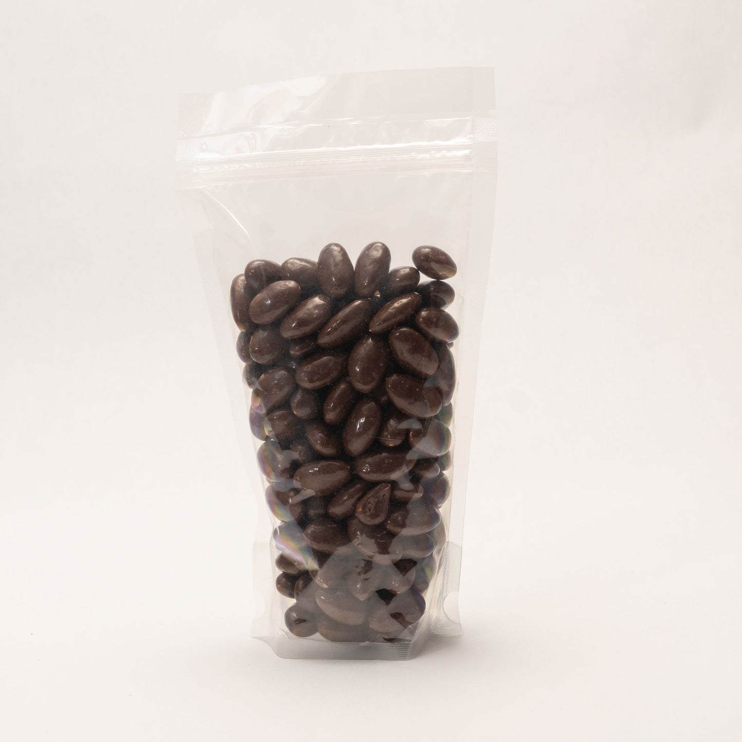 Back view of a clear bag filled with chocolate and sea salt covered almonds