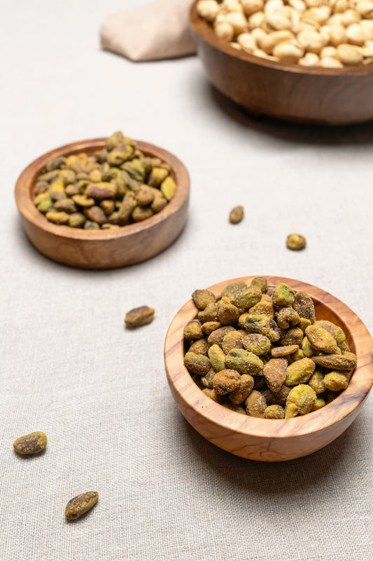 Wooden bowl filled with jalapeno lime flavored unshelled pistachios