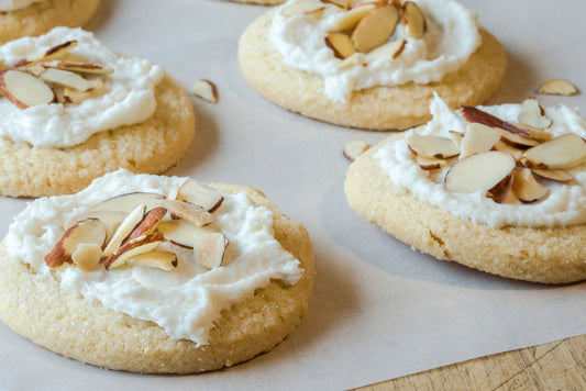Almond cookies topped with brown butter icing and sliced almonds