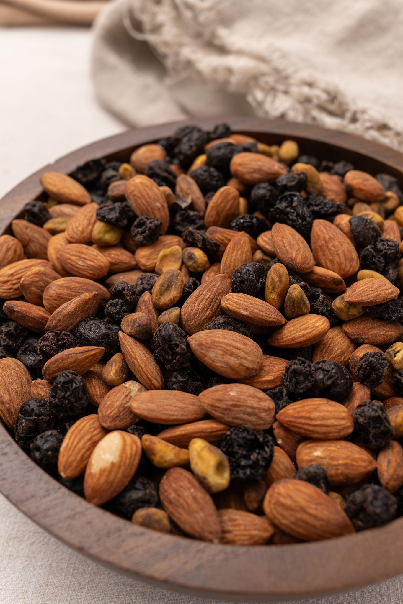 Wooden bowl filled with assorted almonds and dried fruits