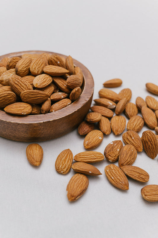 Wooden bowl filled with dry roasted almonds