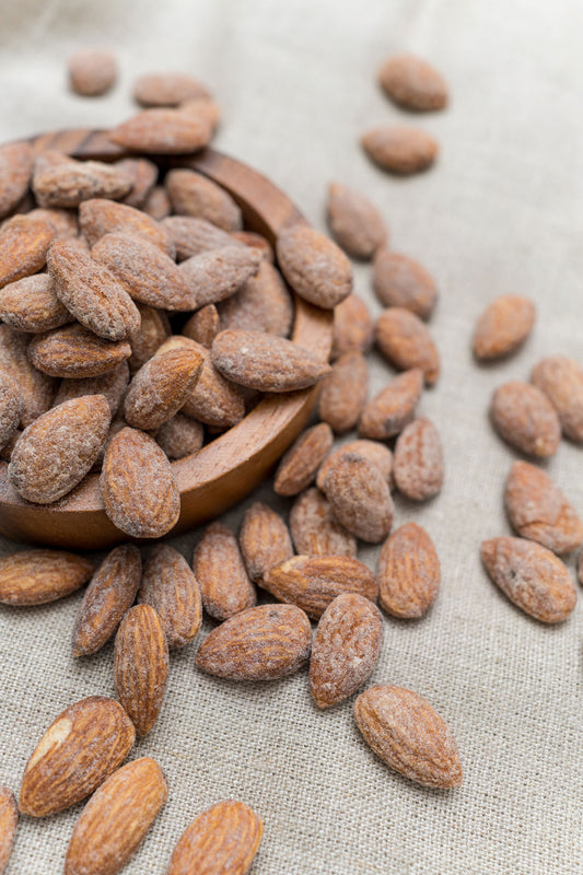 Wooden bowl filled with roasted and salted almonds