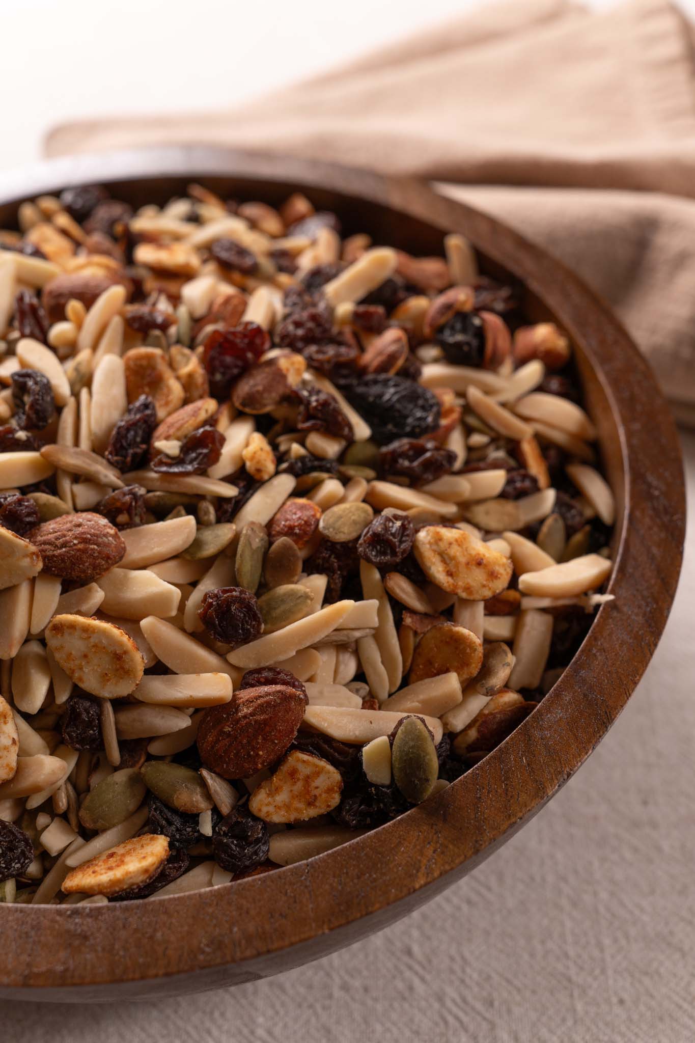 Wooden bowl filled with assorted nuts and raisins