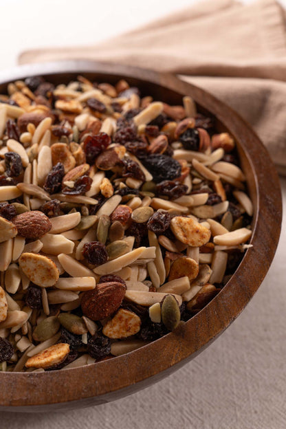 Wooden bowl filled with assorted nuts and raisins
