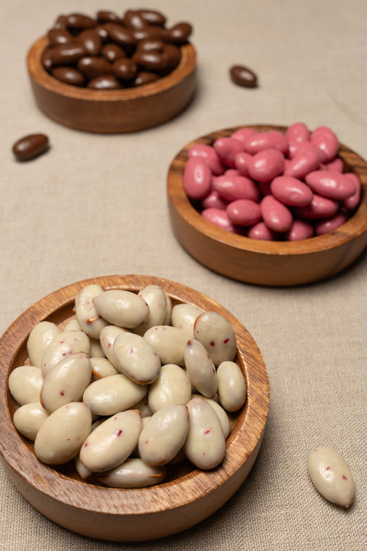 Wooden bowl filled with white chocolate peppermint almonds