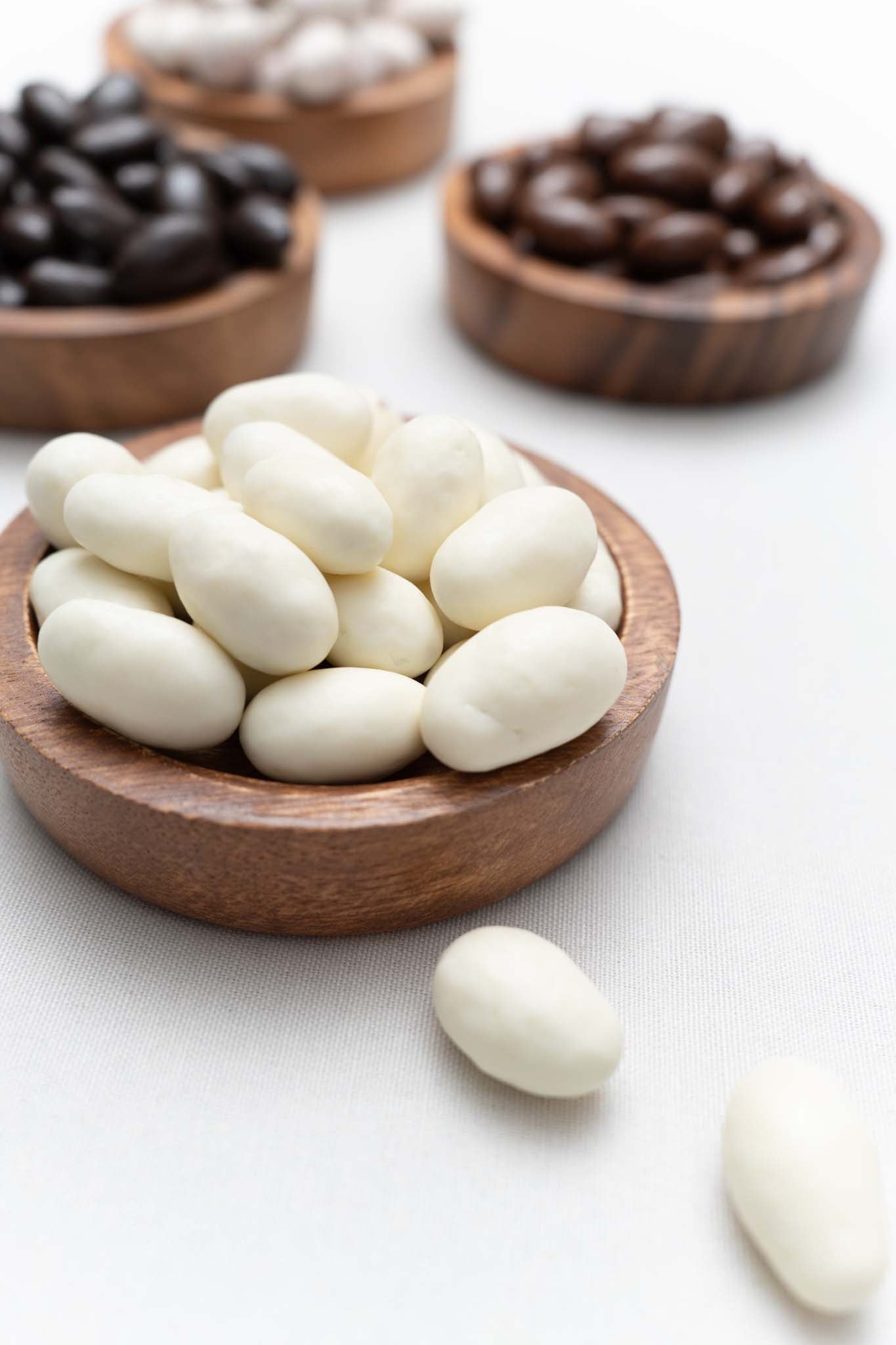 Wooden bowl filled with yogurt covered almonds