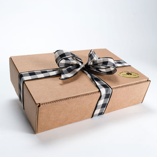 Brown gift box with a black and white checkered ribbon on a white background