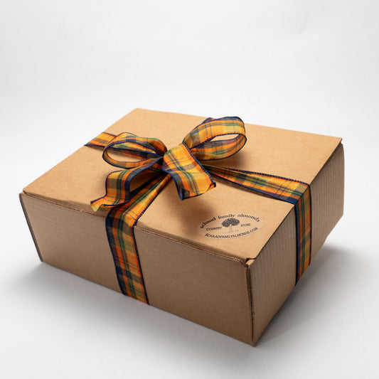 Brown gift box wrapped with a plaid colored ribbon