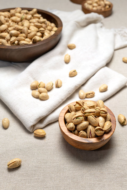 Wooden bowl filled with garlic flavored pistachios