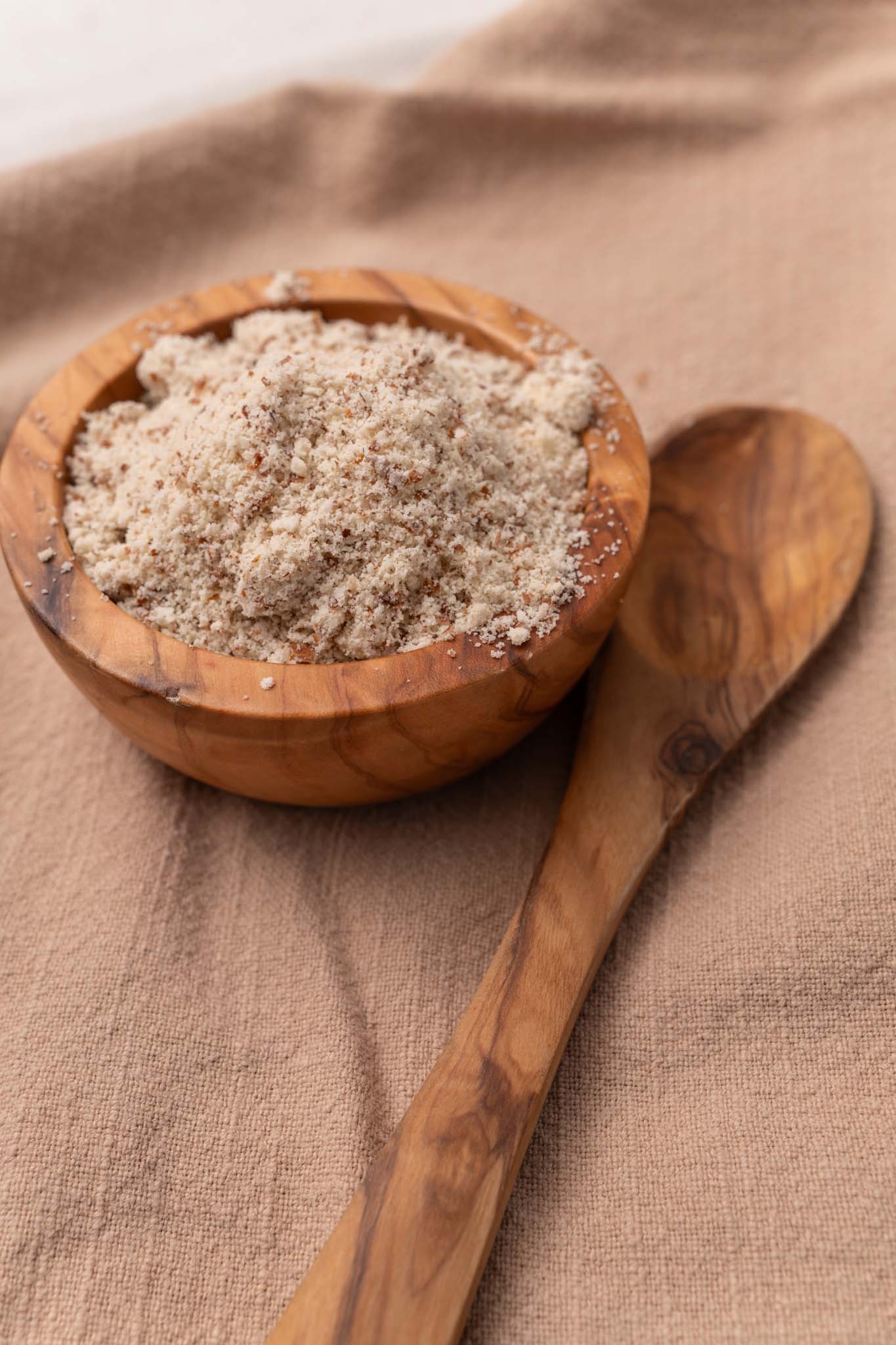 Wooden bowl filled with raw almond flour