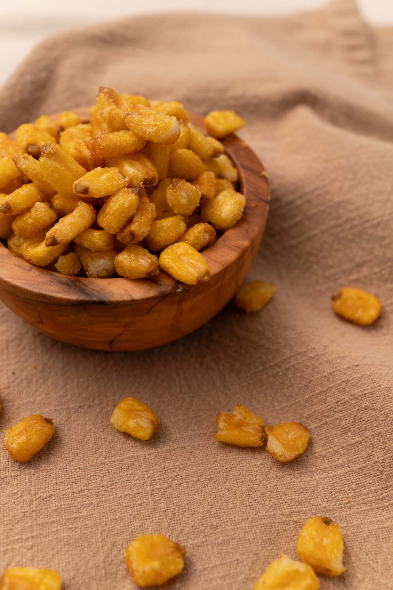 Wooden bowl filled with roasted and toasted corn nuggets